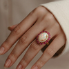 Prism of Light Opal Cabochon with Oval Ruby Surround In Diamond